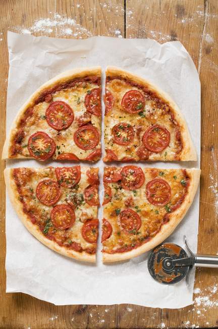 Pizza with oregano on paper — Stock Photo