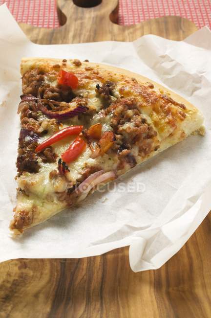 Pizza on paper and desk — Stock Photo