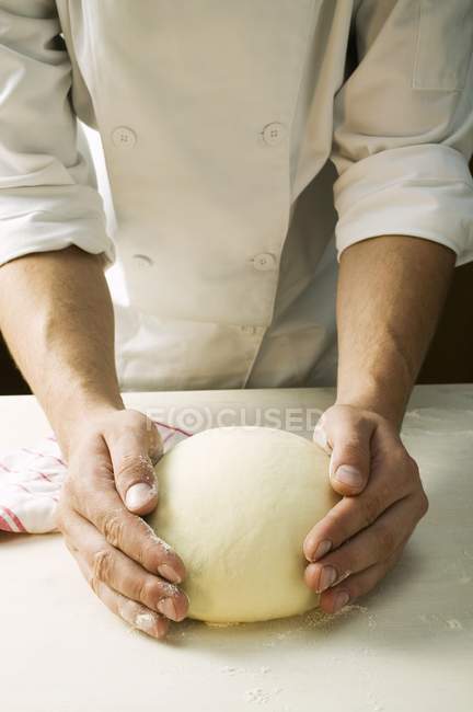 Шеф-повар смешивает тесто для пиццы — стоковое фото