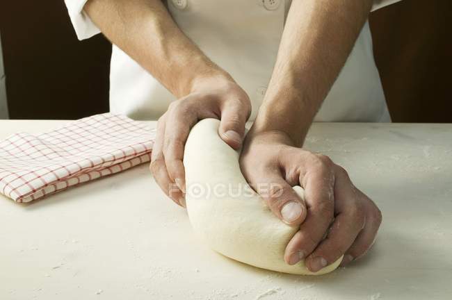 Chef kneading pizza dough — Stock Photo