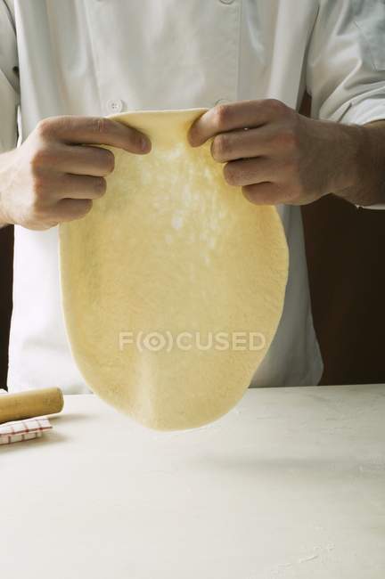 Шеф-кухар розтягує тісто для піци — стокове фото