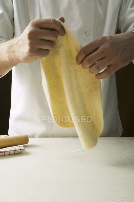 Chef stretching pizza dough — Stock Photo