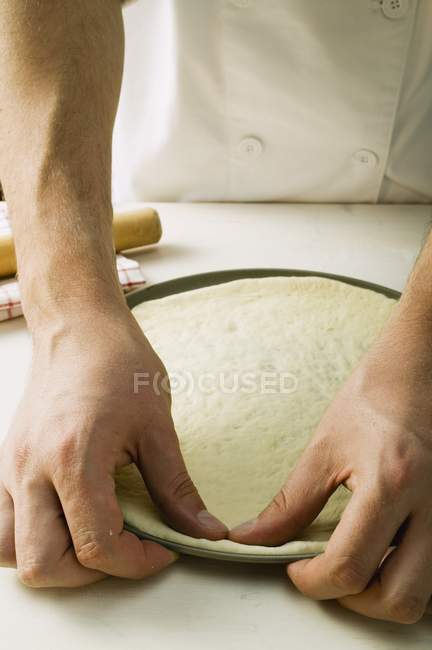 Шеф-повар нажимает тесто для пиццы — стоковое фото