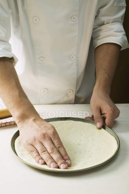 Chef pressing pizza dough — Stock Photo