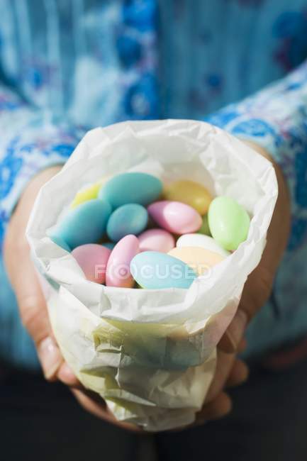 Female hands holding sugared almonds — Stock Photo
