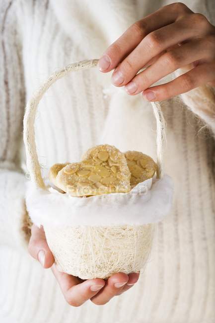 Female hands holding almond biscuits — Stock Photo