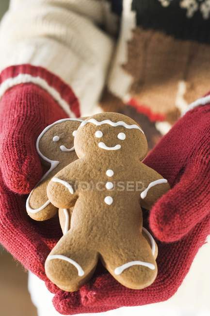 Hands holding gingerbread men — Stock Photo