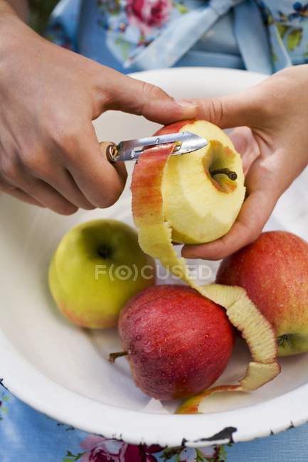 Mains féminines Peler la pomme — Photo de stock