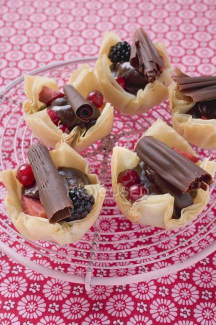 Tarts with berries and chocolate rolls — Stock Photo