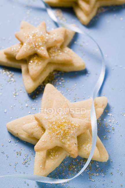 Closeup view of pastry stars with sugar and blue ribbon — Stock Photo