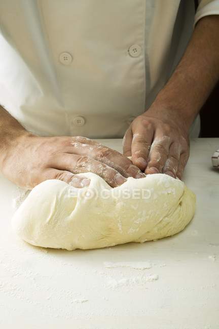 Шеф-повар смешивает тесто для пиццы — стоковое фото