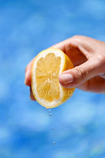 Жіноча рука стискає лимон — стокове фото