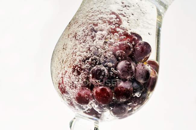 Grapes in a glass of water — Stock Photo