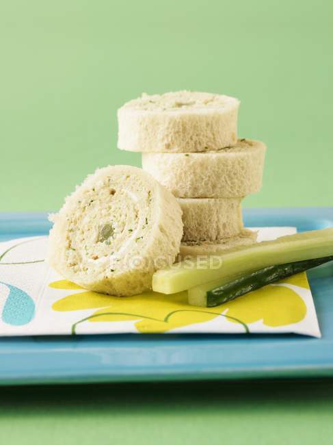 Egg pinwheel sandwiches with celery on blue platter over green background — Stock Photo