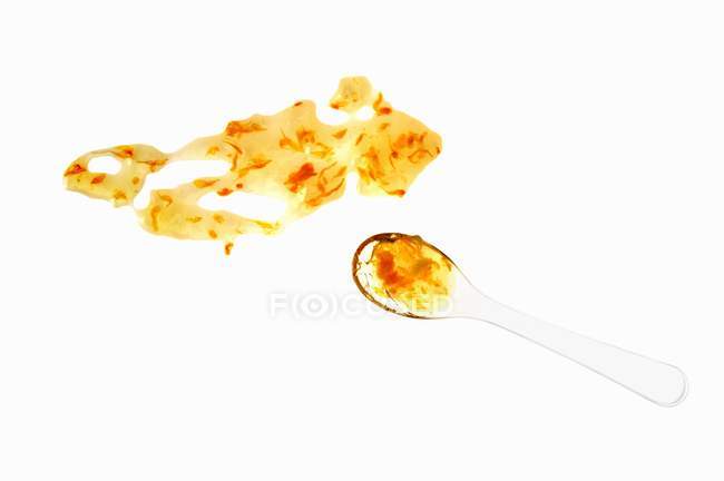 Closeup view of orange marmalade with spoon on white surface — Stock Photo