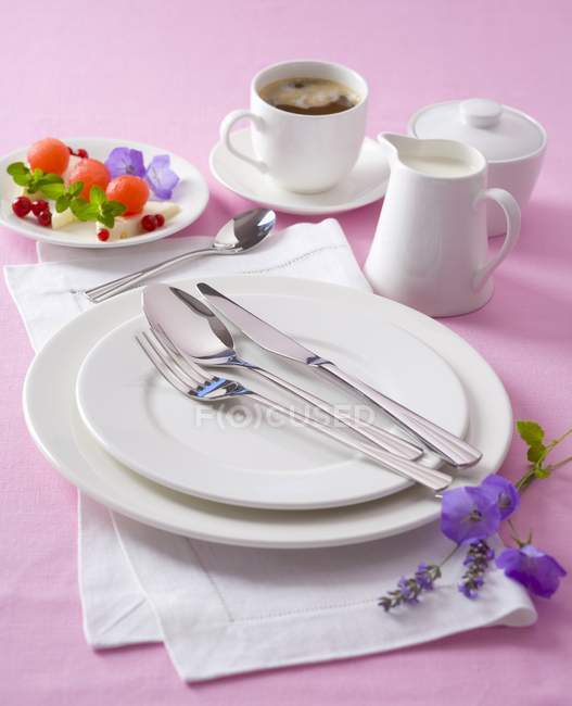 White place setting with coffee, milk, sweets and flowers — Stock Photo
