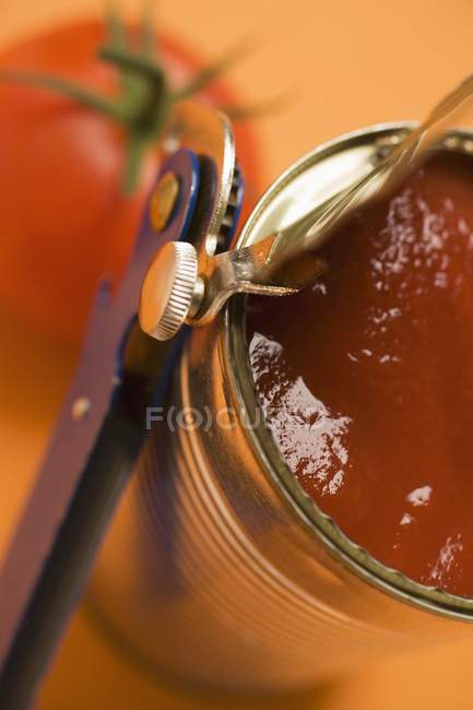 Tinned tomatoes over orange blurred surface — Stock Photo