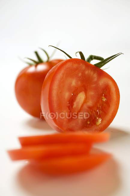 Two tomatoes partly sliced — Stock Photo