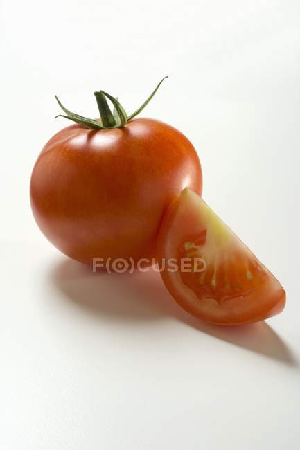 Wedge and whole tomatos — Stock Photo