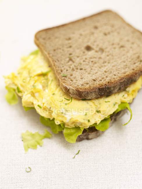 Scrambled egg sandwich laying on white surface — Stock Photo