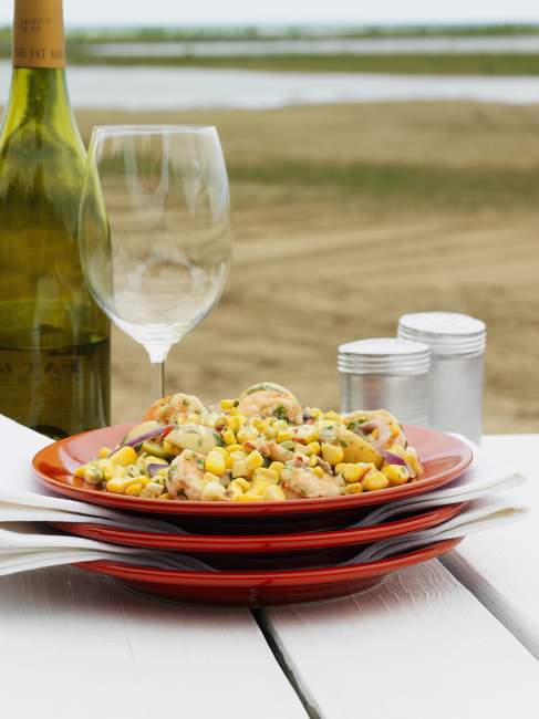 Closeup view of sweetcorn and prawn salad with white wine — Stock Photo