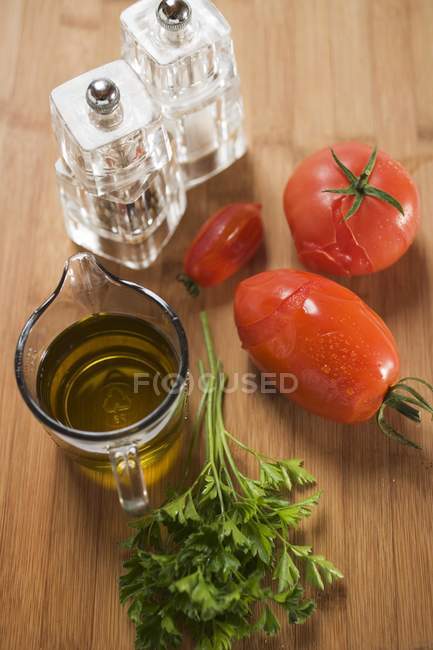 Ingredientes de molho de tomate: tomates, salsa, azeite, sal sobre a superfície de madeira — Fotografia de Stock