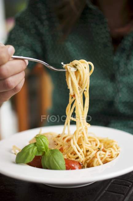Donna che mangia spaghetti con pomodori — Foto stock