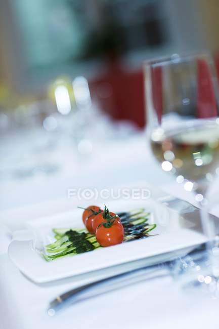 Aperitivo: tomates, calabacines, vinagre balsámico y pesto en plato blanco - foto de stock