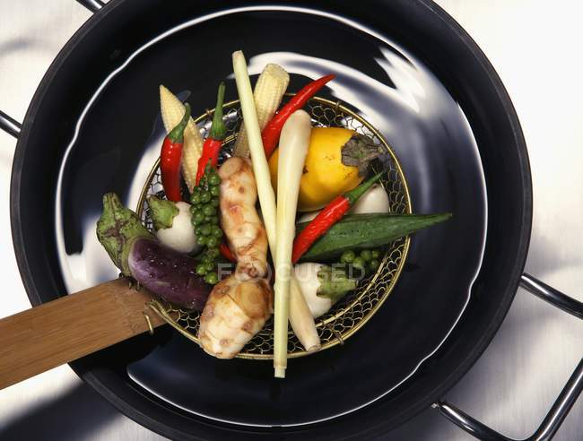 Gemüse für Thaisuppe im schwarzen Wok über Holzfläche — Stockfoto