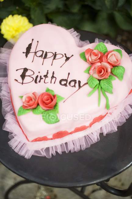 Pastel de cumpleaños rosa en forma de corazón - foto de stock