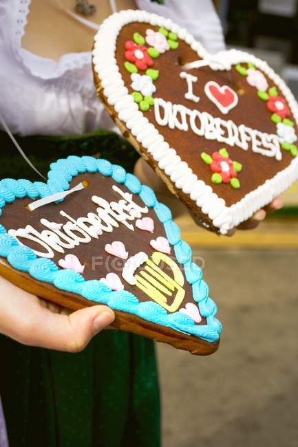 Cropped view of hands holding Lebkuchen hearts — Stock Photo
