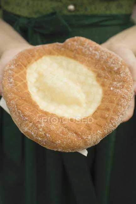 Closeup cropped view of person holding Auszogene Bavarian fried pastry on napkin — Stock Photo