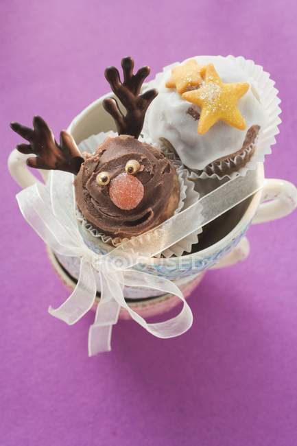 Magdalenas de chocolate en una pila de tazas - foto de stock