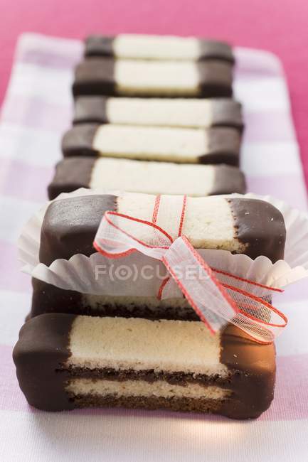 Vista close-up de chocolate em camadas e dedos lisos — Fotografia de Stock