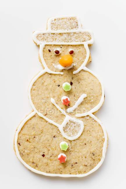 Closeup view of one spiced snowman biscuit on white surface — Stock Photo