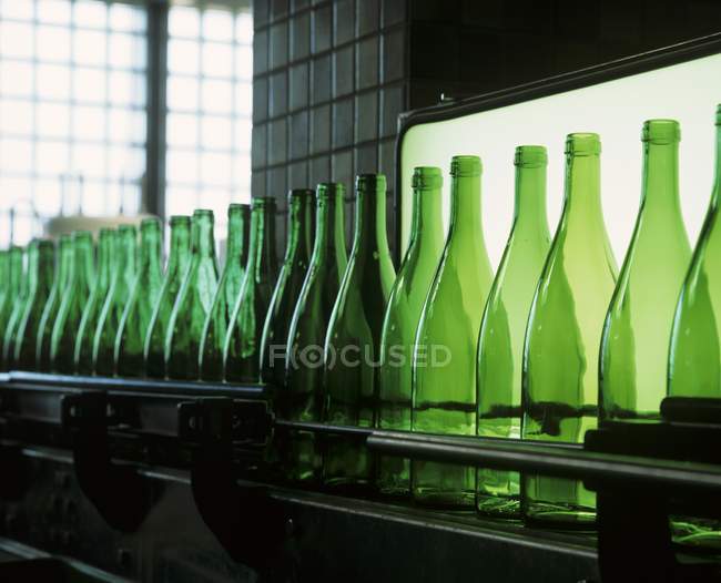 Ряд порожніх пляшок вина на конвеєрній виробничій лінії на заводі розливу — стокове фото