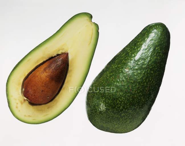 Halved avocado with stone — Stock Photo