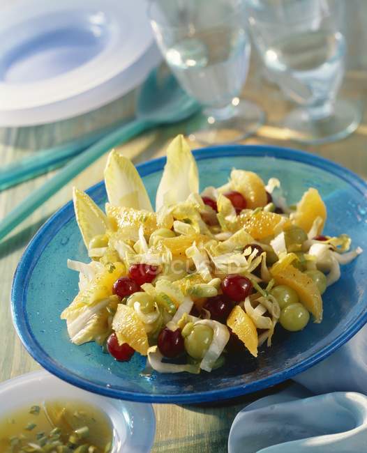 Salade de chicorée aux fruits sur assiette — Photo de stock
