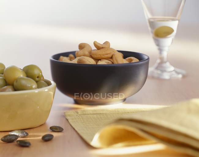Aceitunas, anacardos y Martini - foto de stock