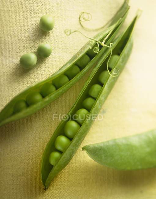 Opened pea pods with peas — Stock Photo