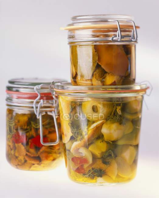 Eingelegtes Gemüse in drei Gläsern auf weißem Hintergrund — Stockfoto