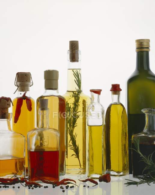 Різні види олії в пляшках з травами і спеціями — стокове фото