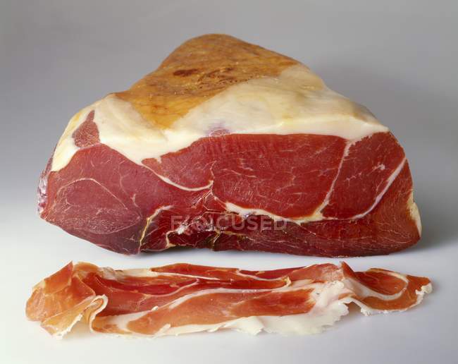 Partly sliced Parma ham — Stock Photo