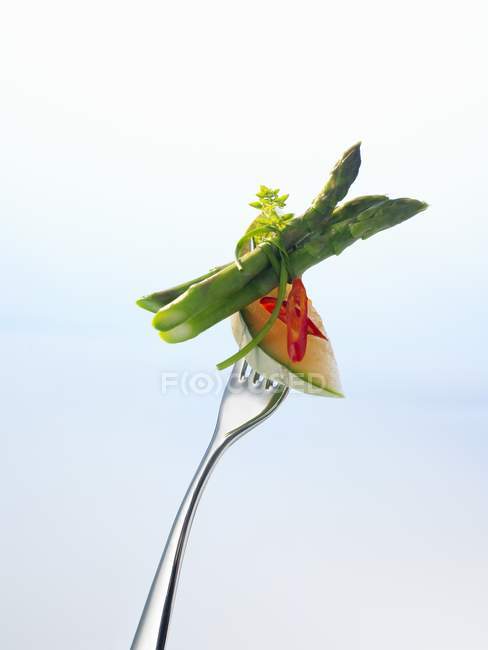 Melón con chile y espárragos en tenedor - foto de stock