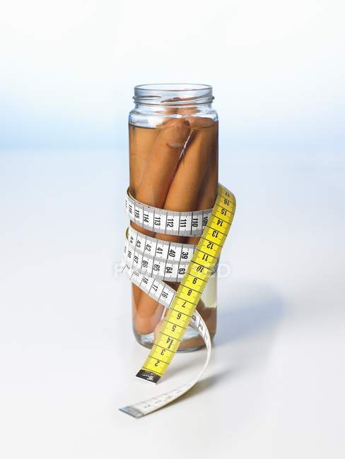 Frankfurters in a jar with a tape measure — Stock Photo