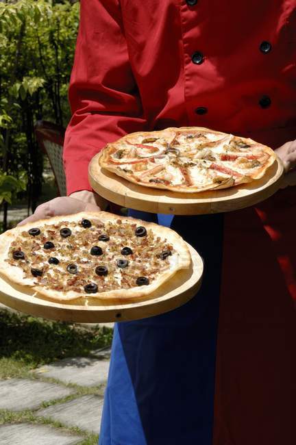 Chef carregando duas pizzas — Fotografia de Stock