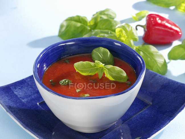 Tomato and red pepper soup with basil — Stock Photo