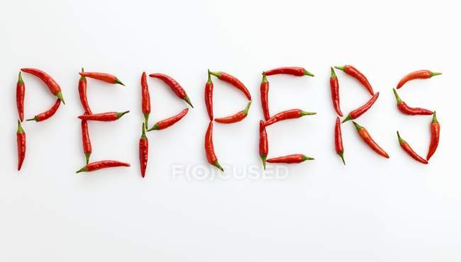 Word peppers written in red chillies — Stock Photo