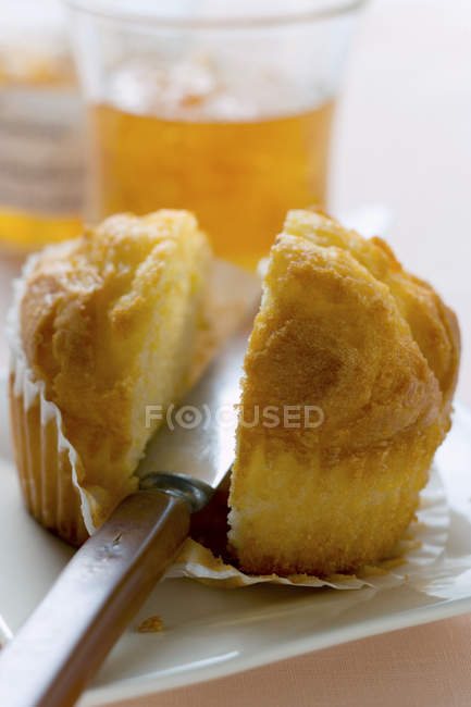 Muffin a la mitad con cuchillo en placa - foto de stock