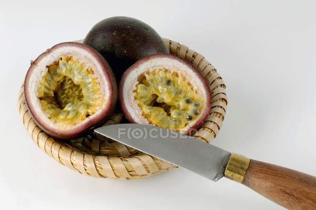 Passion fruits in basket with knife — Stock Photo